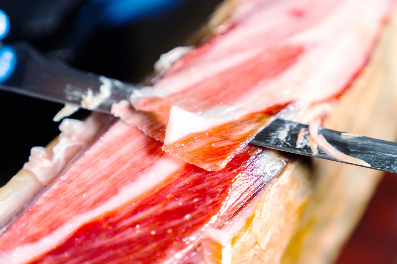 Detalle de cuchillo cortando una loncha de jamón ibérico de bellota