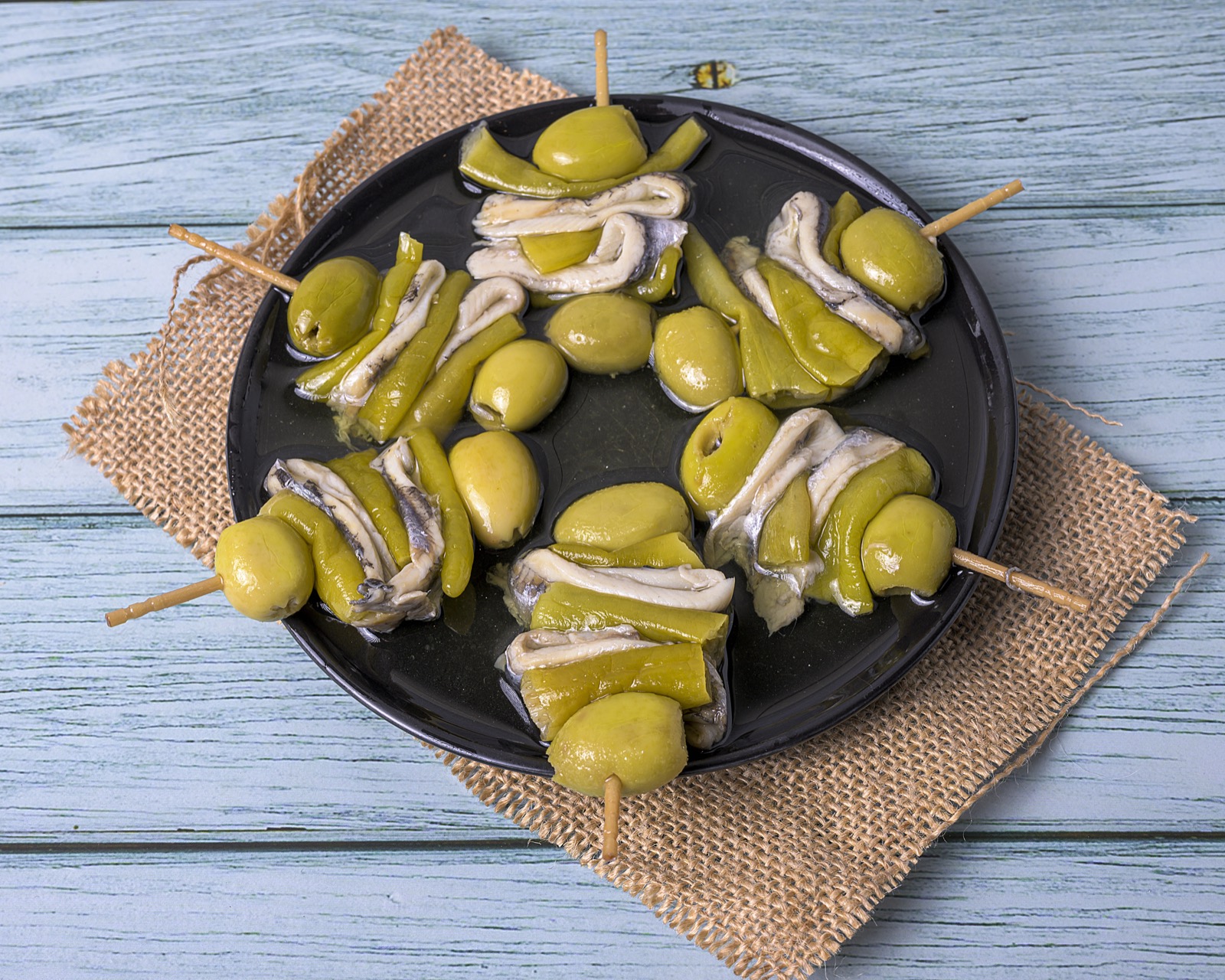 Gildas de anchoa, aceituna y piparra sobre plato negro