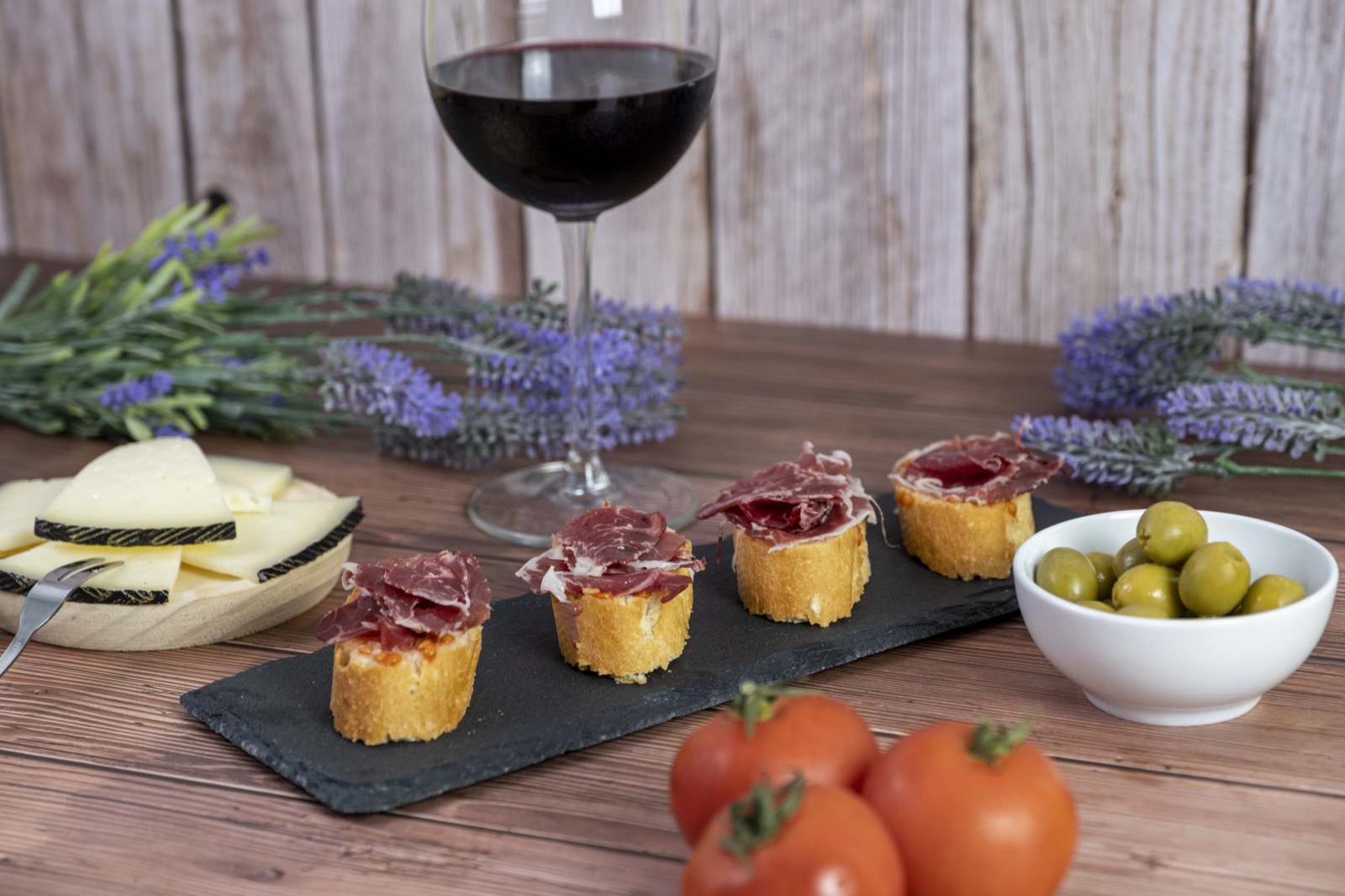 Montaditos de jamón ibérico, queso, aceitunas y copa de vino tinto