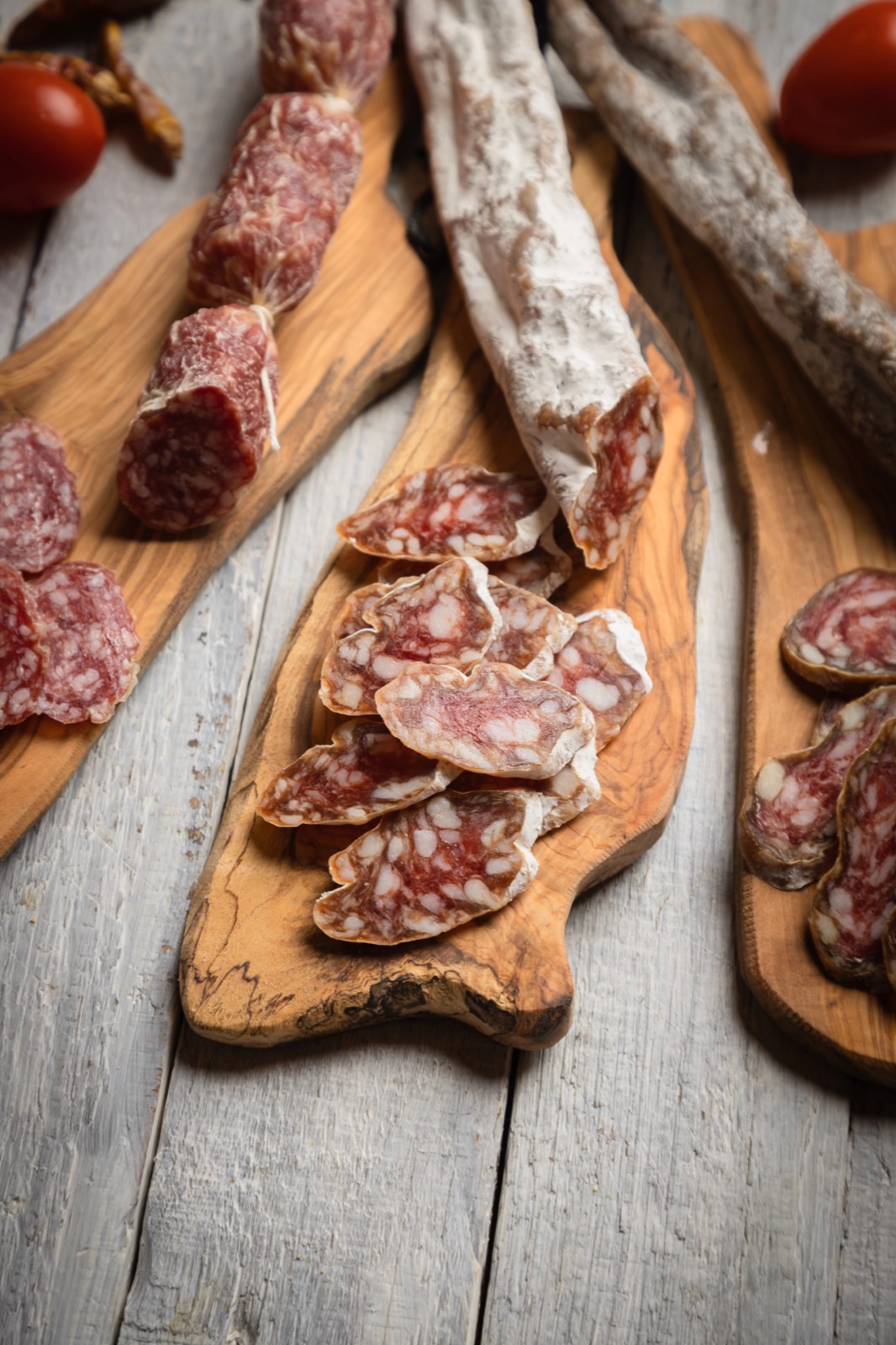 Salchichón y embutidos ibéricos curados cortados sobre tablas de madera